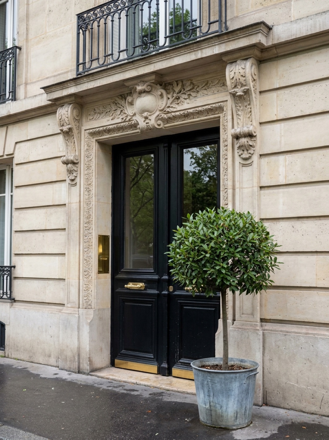 L’entrée du cabinet : une porte noire à poignées de laiton dans un immeuble haussmannien.