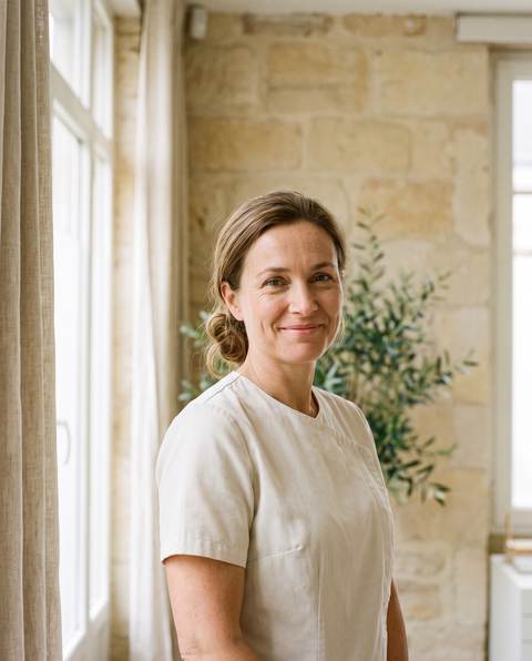 Le Dr Juliette Brémond, souriante, dans son cabinet aux murs de pierre blonde