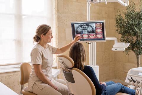 Le Dr Brémond montre à l'écran une radiographie à sa patiente