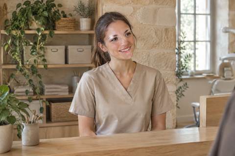 Margaux, l'assistante, au comptoir d'accueil