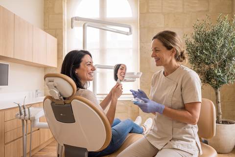Le Dr Brémond tend une gouttière transparente à une patiente