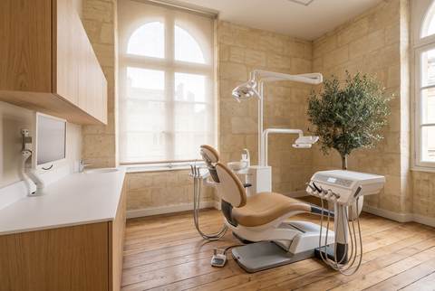 La salle de soins aux murs de pierre blonde, baignée de lumière
